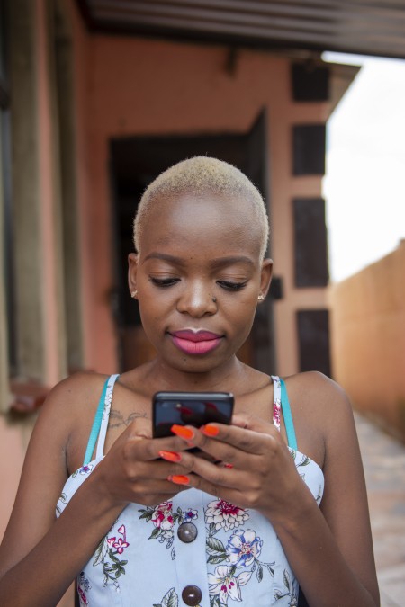 A woman of colour is using a mobile phone.